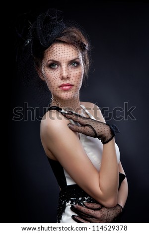 mysterious girl in an evening dress with gloves and a grid on the face