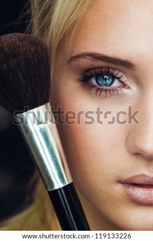 makeup woman with make up brush. half face