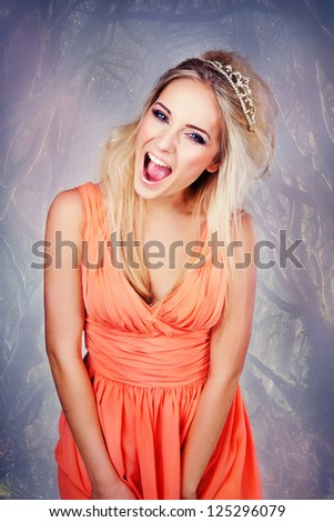 woman in orange dress with crown is shouting