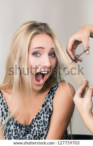 Shocked woman have a bad haircut in the salon