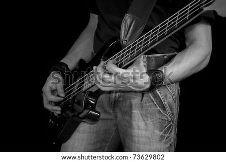 man playing his bass guitar, black and white