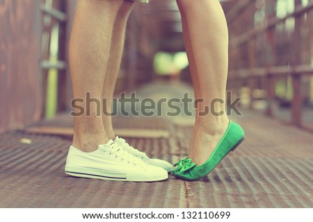 Male and female legs and green shoes