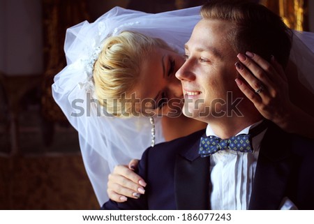 Bride kissing the groom in the hotel
