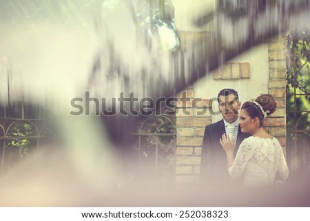 Bride and groom being seen through a parked car
