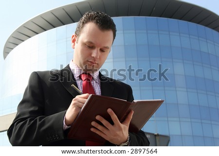 Business man in the middle of writing up the business building