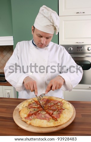 Chef is cutting pizza slice to try the taste of it