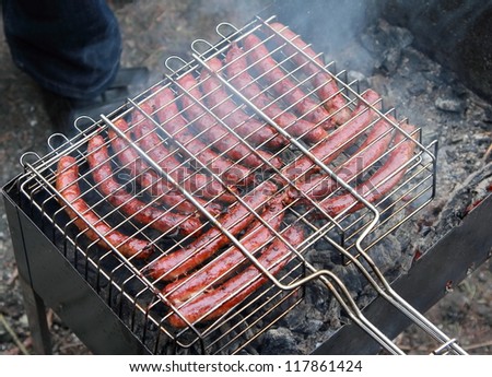 Hot sausages on barbecue cooking outdoor