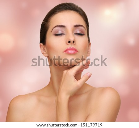 Beautiful woman touching face clean skin on pink background