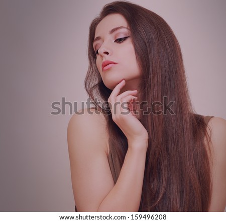 Sexy beautiful girl looking down with hand at face with long hair. Art closeup portrait