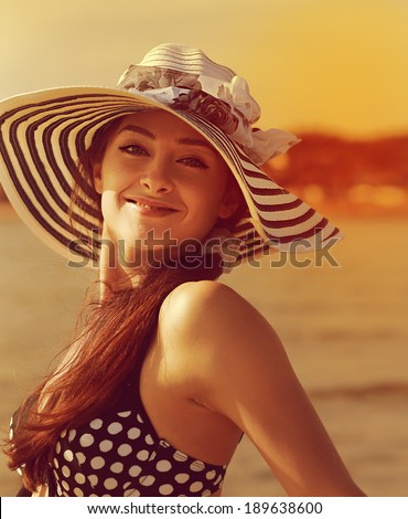 Happy young woman in hat joy on sunny sea background. Closeup bright portrait