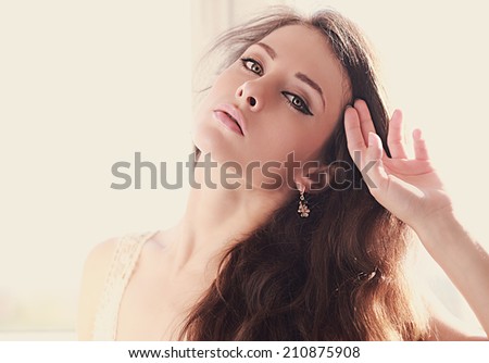 Beautiful woman with green eyes touching hand the long hair. Art closeup portrait