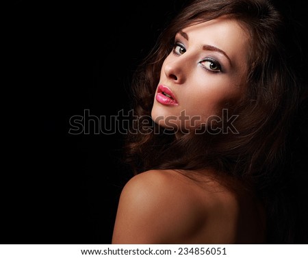 Beautiful expression woman looking in dark shadows. Closeup portrait on black