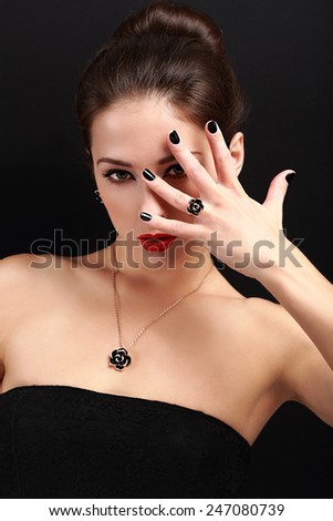 Sexy makeup woman showing her black nails gloss manicure with bright red lipstick