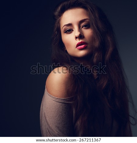 Sexy long hair woman with hot pink lips on dark shadows background looking with passion look. Art color portrait