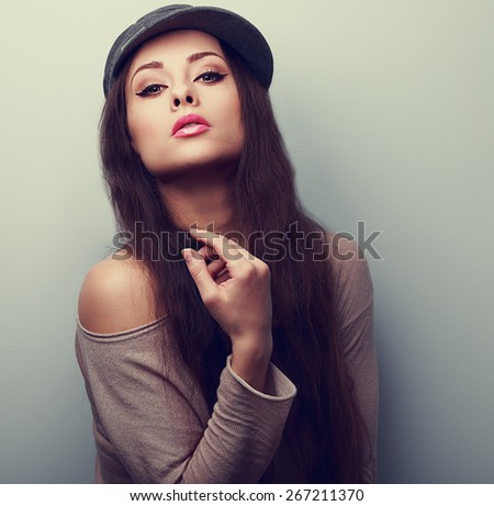 Sexy female model posing in fashion cap. Vintage closeup portrait with empty copy space