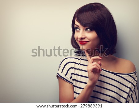Happy thinking woman looking with finger under face on empty copy space. Closeup vintage portrait