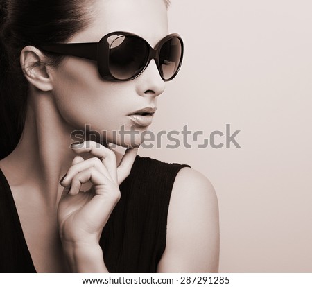Fashionable chic female model profile in fashion sunglasses posing. Black and white color toned portrait