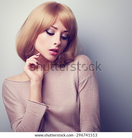 Sexy young blonde woman with short hair style posing. Toned closeup portrait