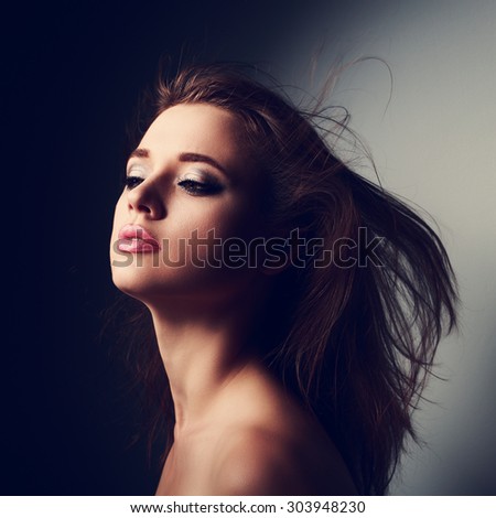 Sexy mysterious makeup woman profile with wind long hair posing. Closeup art portrait