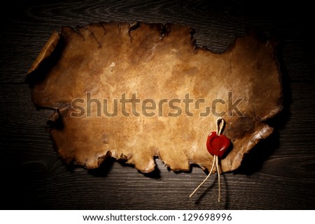 Blank old torn paper with wax stamp on wooden background