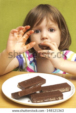 Three years old girl eating cookies