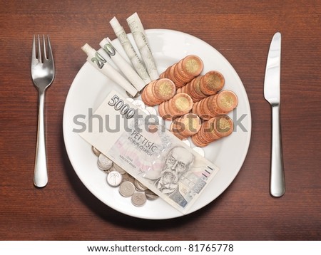 Plate with money instead of food symbolizing expensive food, consumerism or other food and money related concepts.