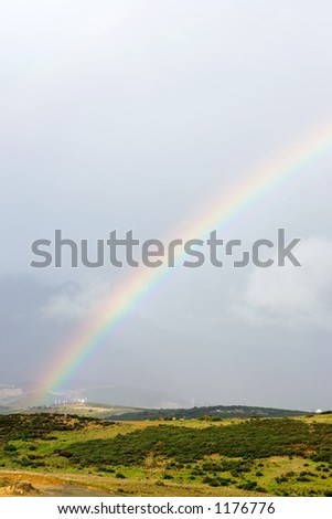 Colourful rainbows end in a field after a big storm in Spain