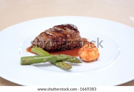 Small plate of gourmet food including fillet of steak meat, asparagus and potato