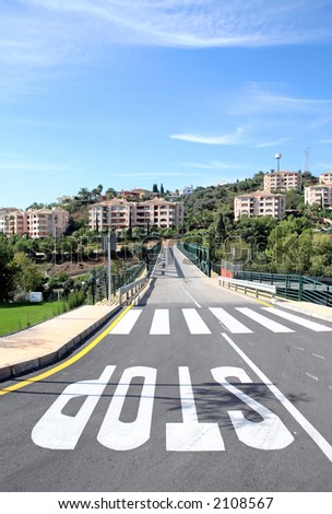 New road and bridge over golf course in Spain with stops signs and zebra or pedestrian crossing