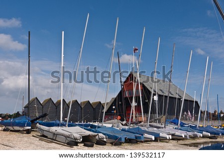 WHITSTABLE, UK-MAY 16: A line of boats lie docked in Whitstable harbour with weathered huts and buildings behind. Whitstable is famous for its oysters and oyster festival.May 16, 2013 in Whitstable UK