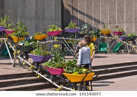 LONDON,UK-JUNE 6: An urban wheelbarrow garden is enjoyed by visitors to the Southbank's festival of neighbourhood, that brings urban gardens and allotments to the centre. June 6, 2013 London UK.
