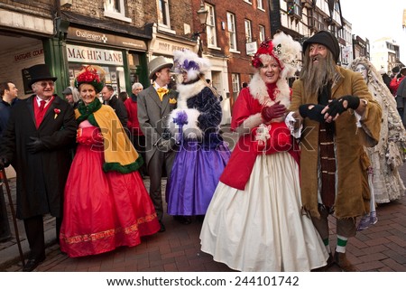 ROCHESTER, UK-DECEMBER 6: Couples dressed in fine Victorian costumes parade in the streets in the annual Rochester Dickensian Christmas Festival,   December 6, 2014, Rochester UK.
