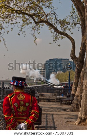 LONDON, UK - APRIL 21: The Honourable Artillery Company fire the 62 round Gun Salute for the Queen\'s birthday at the Tower of London as a Yeoman Warder or Beefeater watches. April 21, 2011 in London UK.