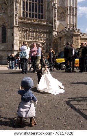 LONDON, UK-APRIL 27: Puppet bride and groom set up by Chantal Calato for a stop action film, capture the Royal Wedding atmosphere in front of Westminster Abbey. April 27, 2011 in London UK