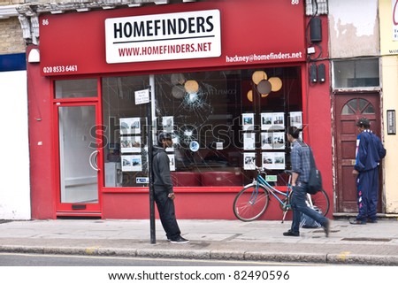 LONDON, UK - AUGUST 9: London Riots.Unidentified men outside Homefinders office where windows have been smashed in the riots along Amhurst road Hackney. August 9, 2011 in London UK.