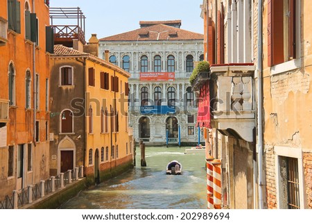 VENICE, ITALY - MAY 06, 2014: People move through the channel on the boat in Venice, Italy