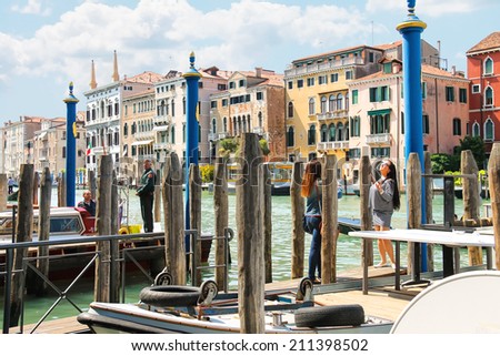 VENICE, ITALY - MAY 06, 2014: People on quay of the Grand Canal  in sunny spring day,Venice, Italy