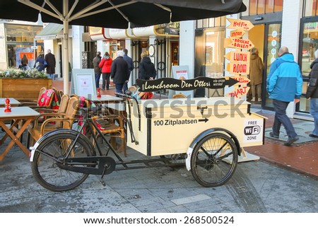 Den Bosch, Netherlands - January 17, 2015: People walk past the carriage for fast food, parked near the restaurant  in the Dutch town Den Bosch.