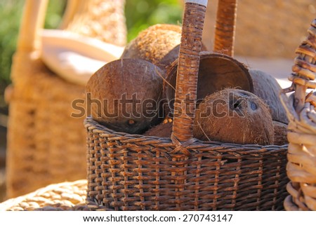 Wicker furniture and basket with coconut on the beach