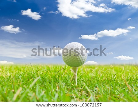 golf ball and tee grass against blue sky