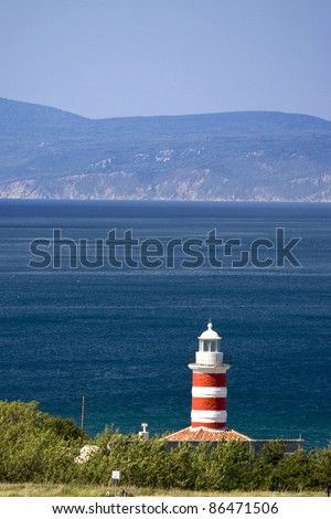Lighthouse of the cape Ostro with the rocky coast and it`s tip