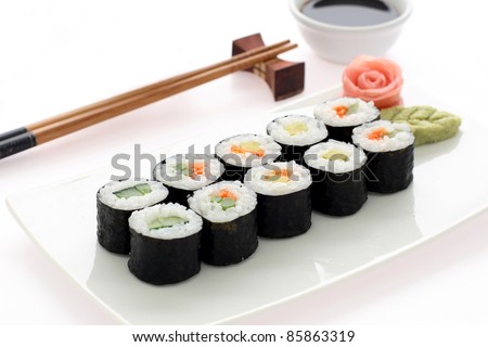 Makizushi. Delicious sushi rolls on white plate with chopsticks and wasabi. Maki