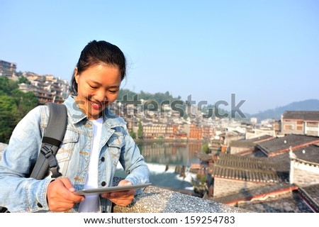 woman tourist use digital tabelt at fenghuang ancient town,china