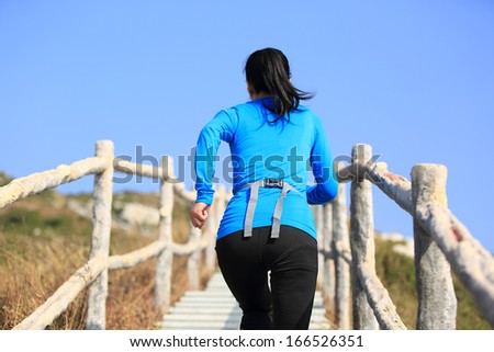 sports woman climbing mountain stairs