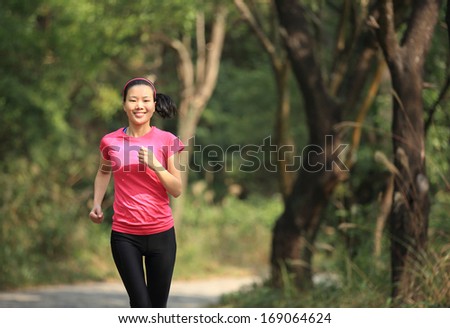healthy sporty woman runner running in forest trail