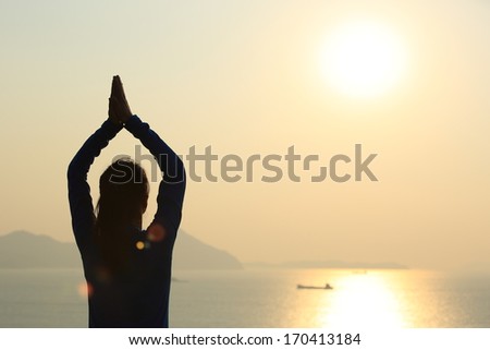 back of healthy yoga woman meditation at sunrise seaside