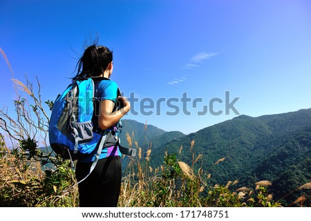 woman climber looking into the wilderness on mountain peak