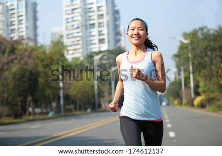 healthy sports woman running at city asphalt street