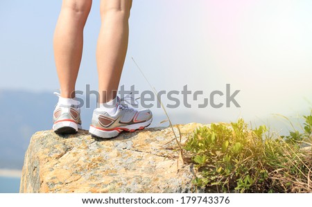 hiker legs stand seaside mountain rock