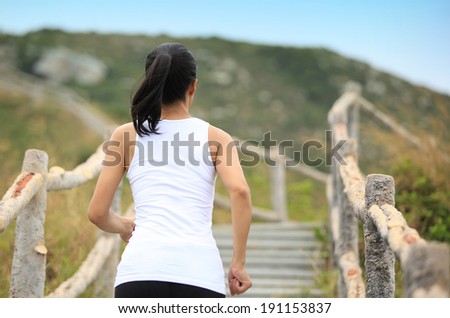 Runner athlete running at mountain stone stairs. woman fitness jogging  workout wellness concept.